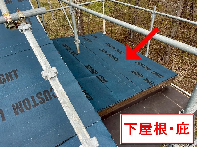 甲府市でアスファルトシングル屋根の下屋根・庇にカバー工法で防水シート（防水紙）を設置する様子