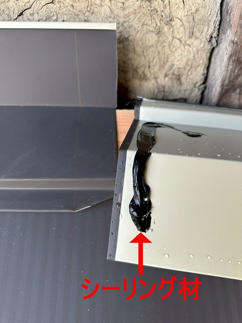 南アルプス市で下屋根の葺き替え工事の際に雨押さえ板金を設置する様子（シーリング処理）