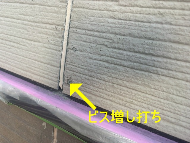 甲府市で外壁塗装前にサイディングボードの反った部分にビス増し打ち作業を行う様子