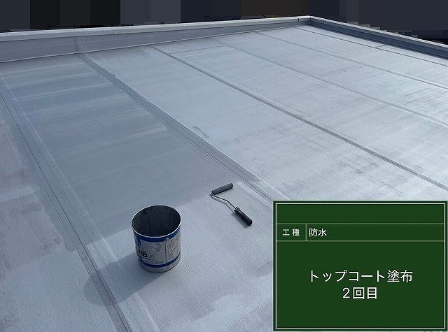 甲斐市で屋上シート防水にトップコートを塗布する様子