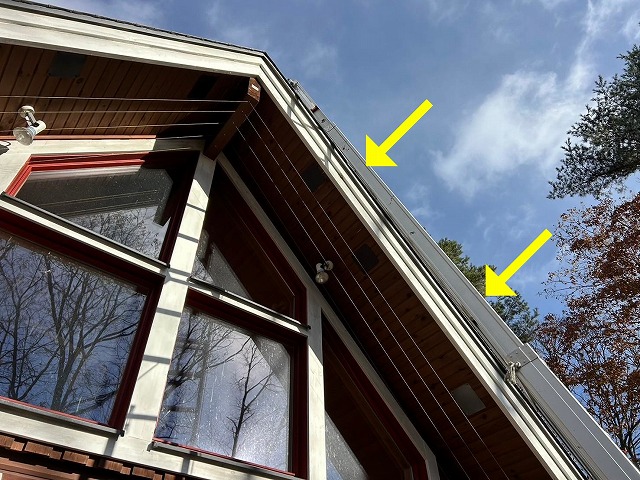 北杜市でキツツキの穴が開いた軒天を伸縮梯子で補修する様子