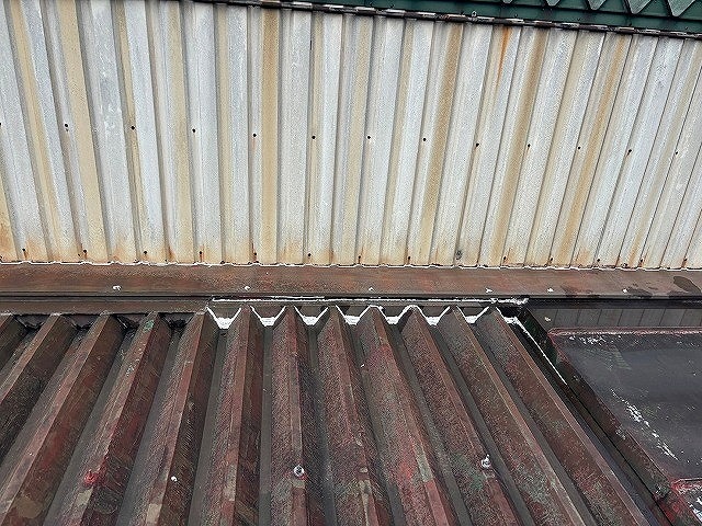 南部町で工場（倉庫）の折板屋根に雨漏りのDIYシーリング補修跡が残る様子