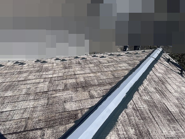 甲府市で屋根塗装前に谷板金・棟板金の継ぎ目に塗装を行う様子