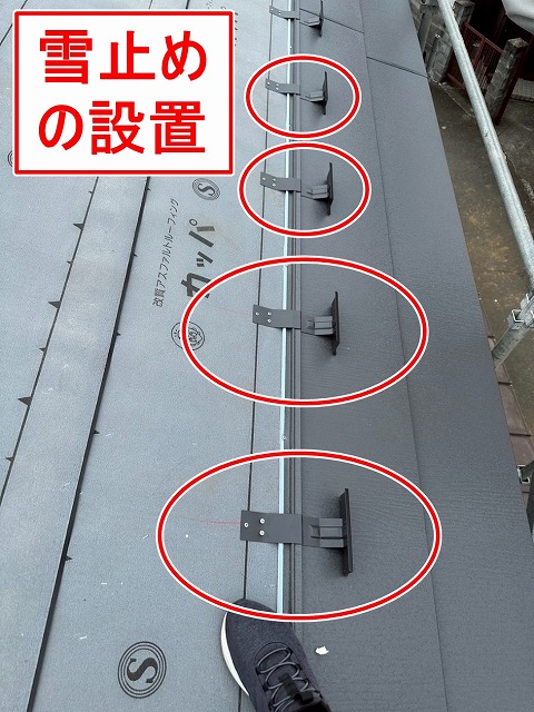 大月市で屋根葺き替え工事の際に、雪止めを設置する様子