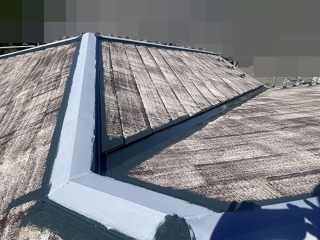 甲府市で屋根塗装前に谷板金・棟板金の継ぎ目に塗装を行う様子