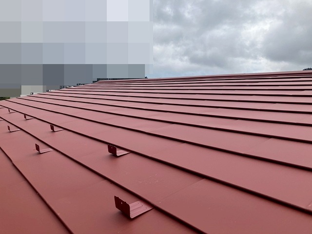 都留市でスレート屋根から断熱材入りSGL鋼板にカバー工法を行う際に雪止めを設置する様子