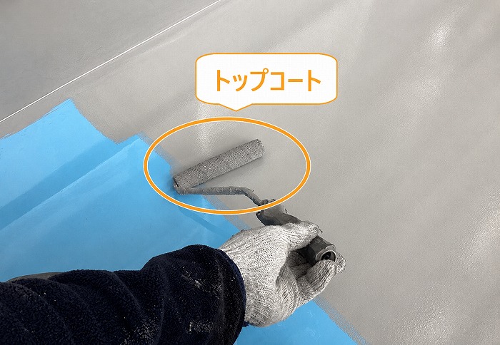 集合住宅のベランダ防水工事でトップコートを塗っている様子