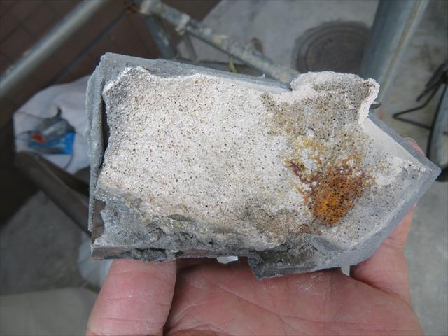 重量鉄骨造の外壁モザイクタイルを近接して観察すると、タイル裏面には接着用モルタルがＡＬＣの一部を剥離させたことが解かる。