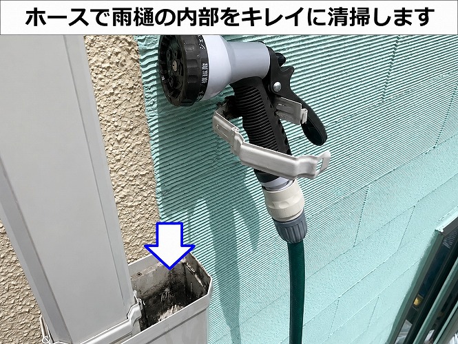 ホースを利用して雨樋の内部を清掃している様子