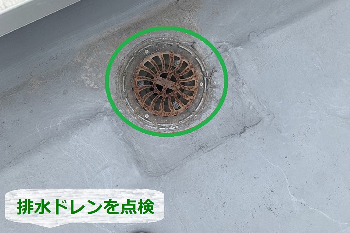 マンション屋上のシート防水調査でドレンを点検している様子