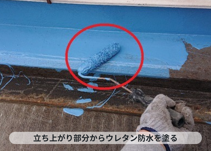 神戸市中央区 神戸市中央区の陸屋根防水工事で立ち上がり部分にウレタン防水を塗っている様子