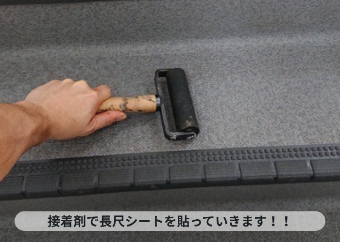 神戸市中央区 接着剤で共用階段に長尺シートを貼っている様子