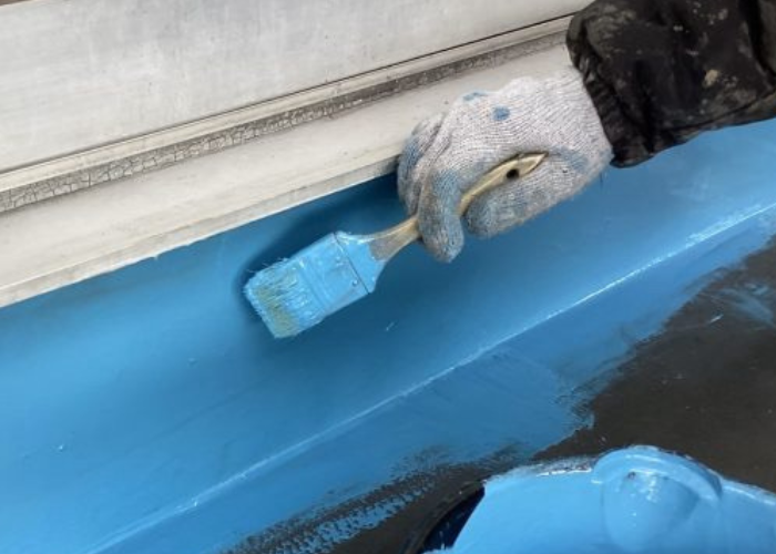 神戸市中央区 ウレタン防水をベランダの立ち上がり部分に塗っている様子