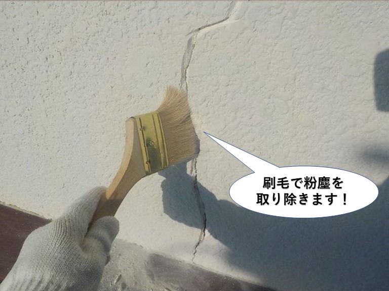 忠岡町のひび割れの溝の中を刷毛で粉塵を取り除きます