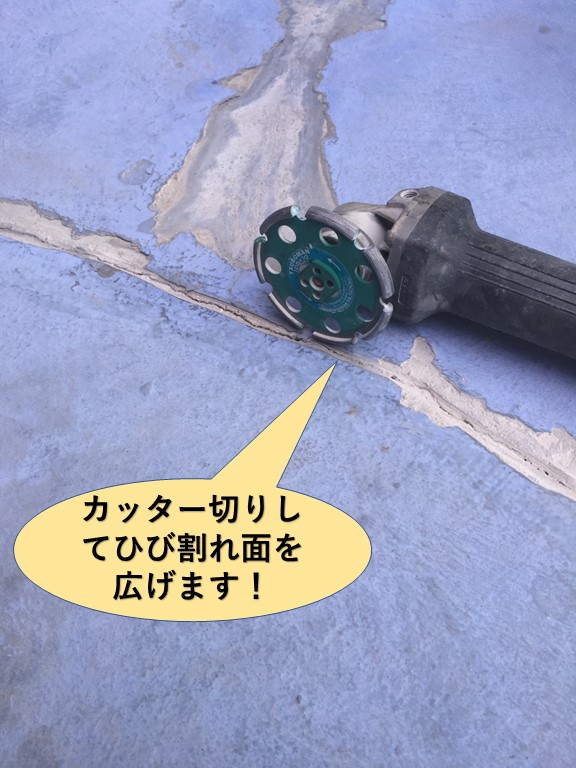 岸和田市のベランダのひび割れをカッター切して面を広げます