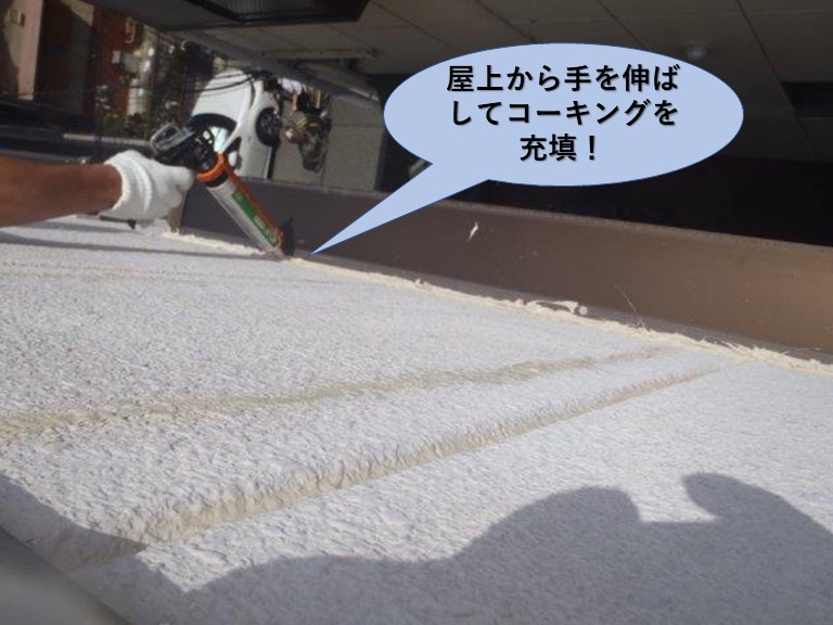堺市のマンションの屋上から手を伸ばしてコーキング充填