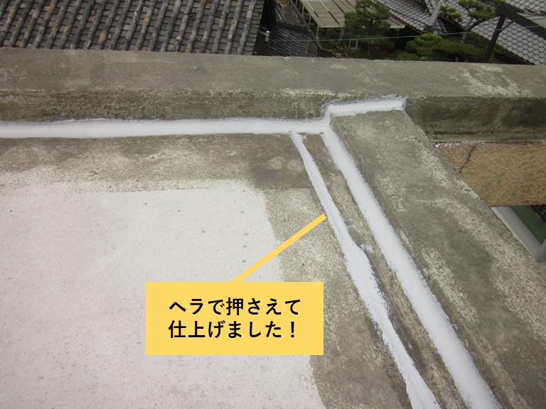 和泉市の陸屋根の目地に充填したシーリングをヘラで押さえました