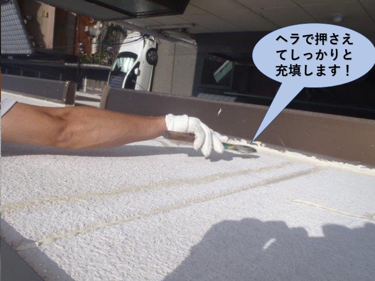 堺市のマンションのコーキングをヘラで押さえてしっかりと充填します