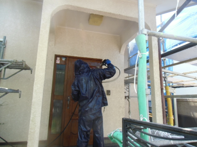 岸和田市天神山町の玄関ドアを洗浄中