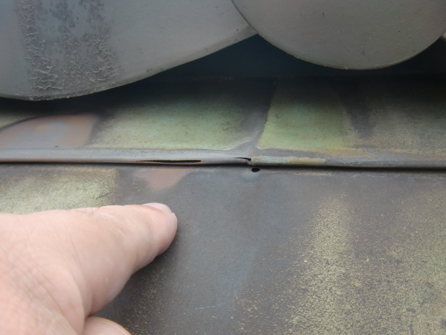 岸和田市の銅板晒し葺きの屋根に穴があいています