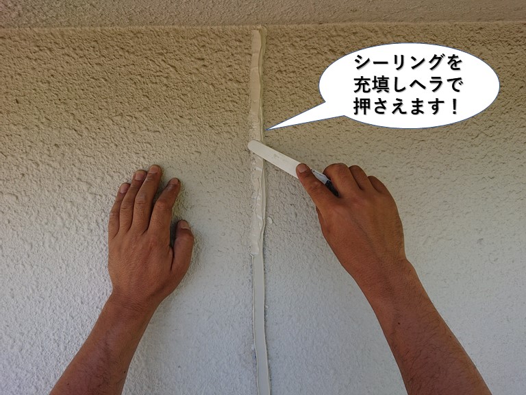 和泉市のひび割れにシーリングを充填しヘラで押さえます