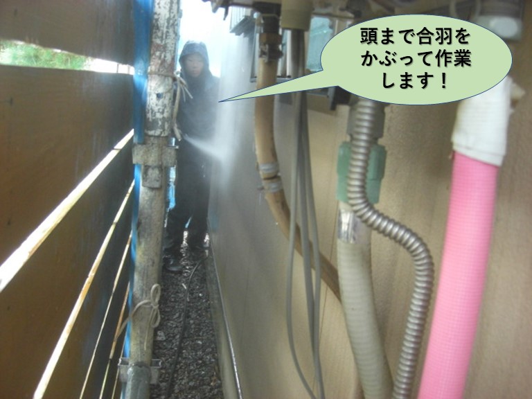 泉佐野市の高圧洗浄で頭まで合羽をかぶって作業します