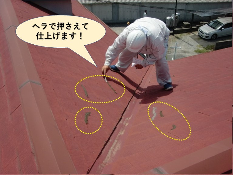 根のひび割れに充填したコーキングをヘラで押さえて仕上げます