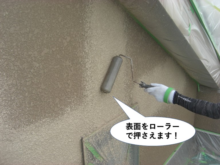 泉大津市の外壁の塗膜の表面をローラーで押さえます