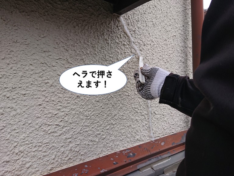 泉佐野市の外壁のひび割れに充填したシーリングをヘラで押さえます