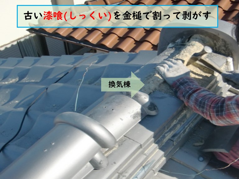 泉南市で風雨災害に遭った現場で古い漆喰(しっくい)を金槌で割って剥がす