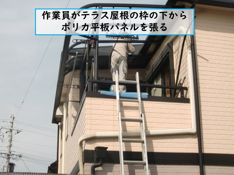 熊取町で作業員がテラス屋根の枠の下からポリカ平板パネルを張る