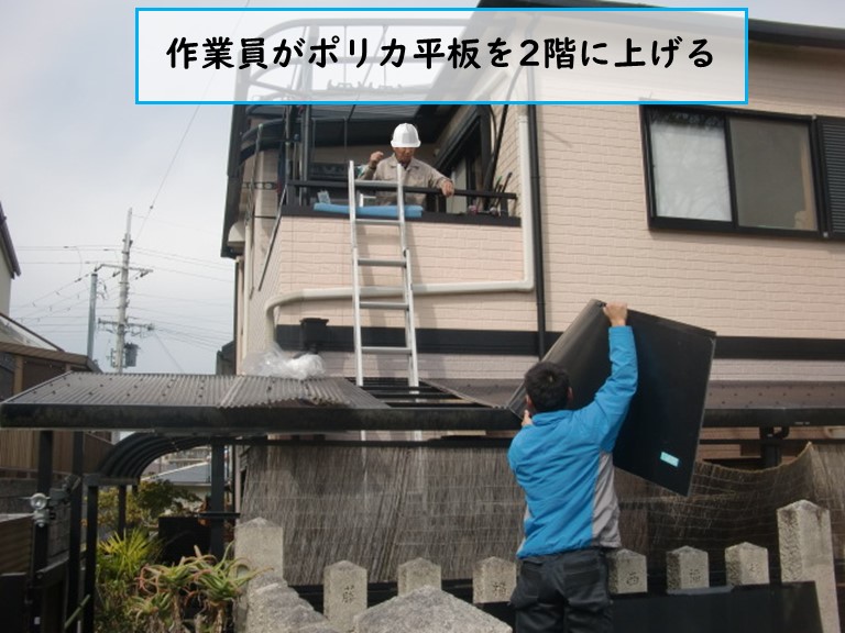 熊取町で作業員がポリカ平板を2階に上げる