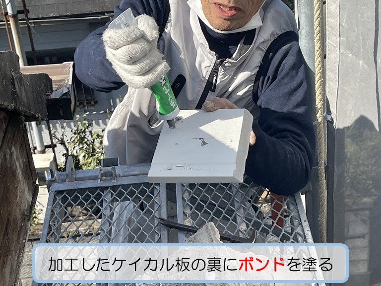 熊取町で強風で剥がれ落ちた破風板を張り替え加工したケイカル板の裏にボンドを塗る