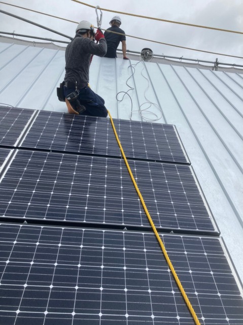 ソーラーパネルを設置する人