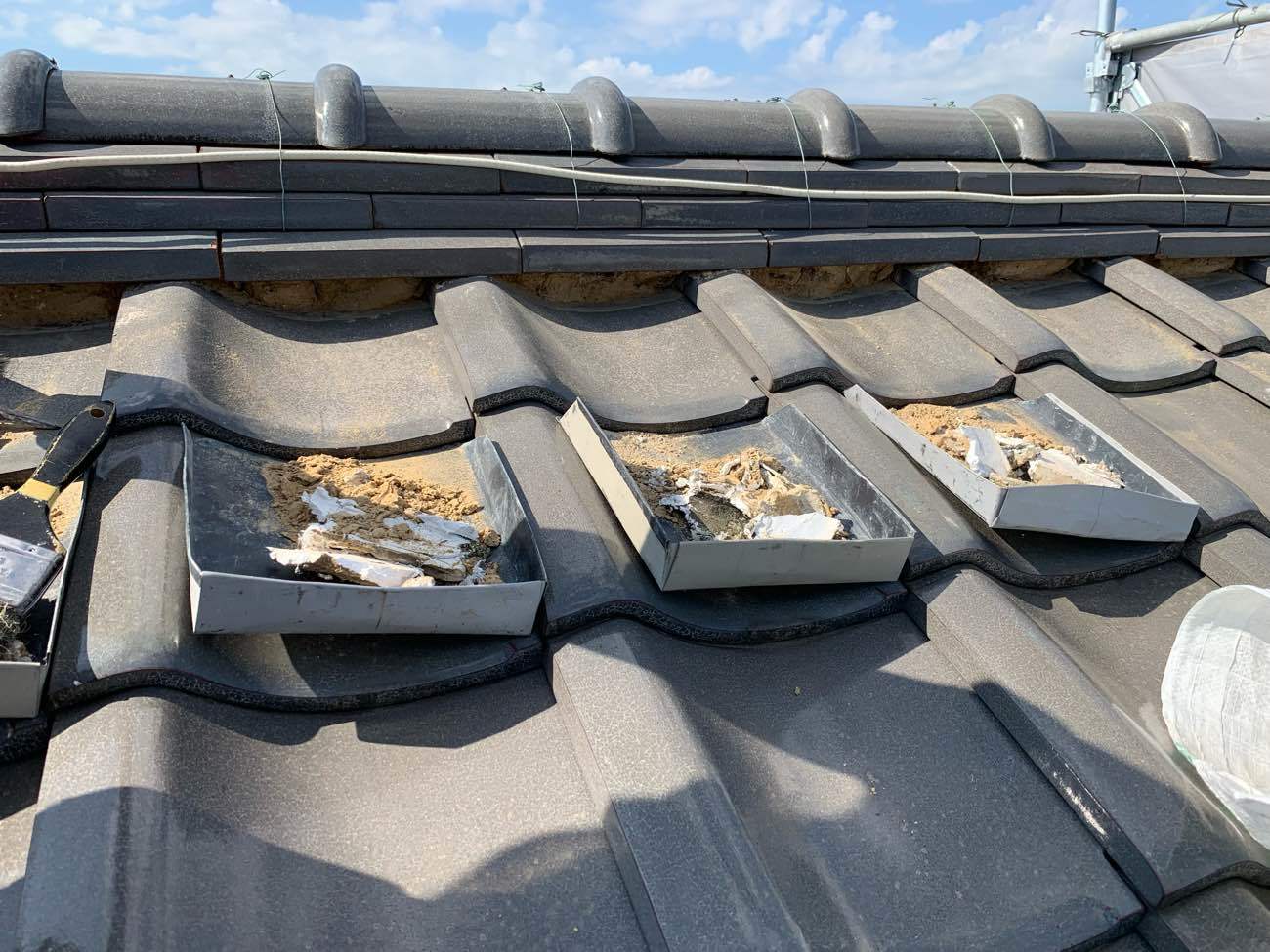 既存の棟の下漆喰を撤去中