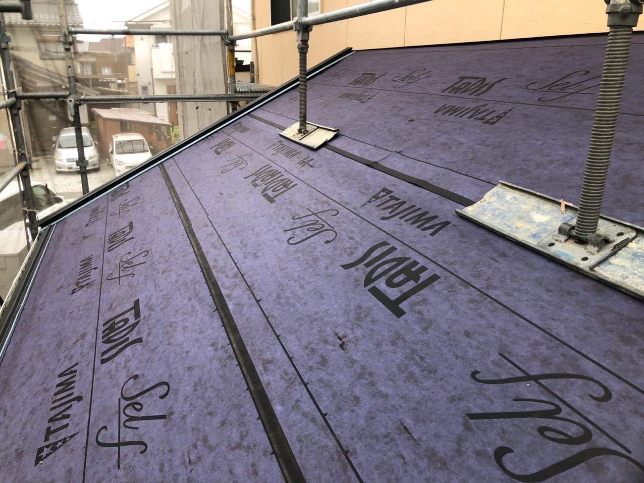 屋根材の表面に直接シートを貼っていきます