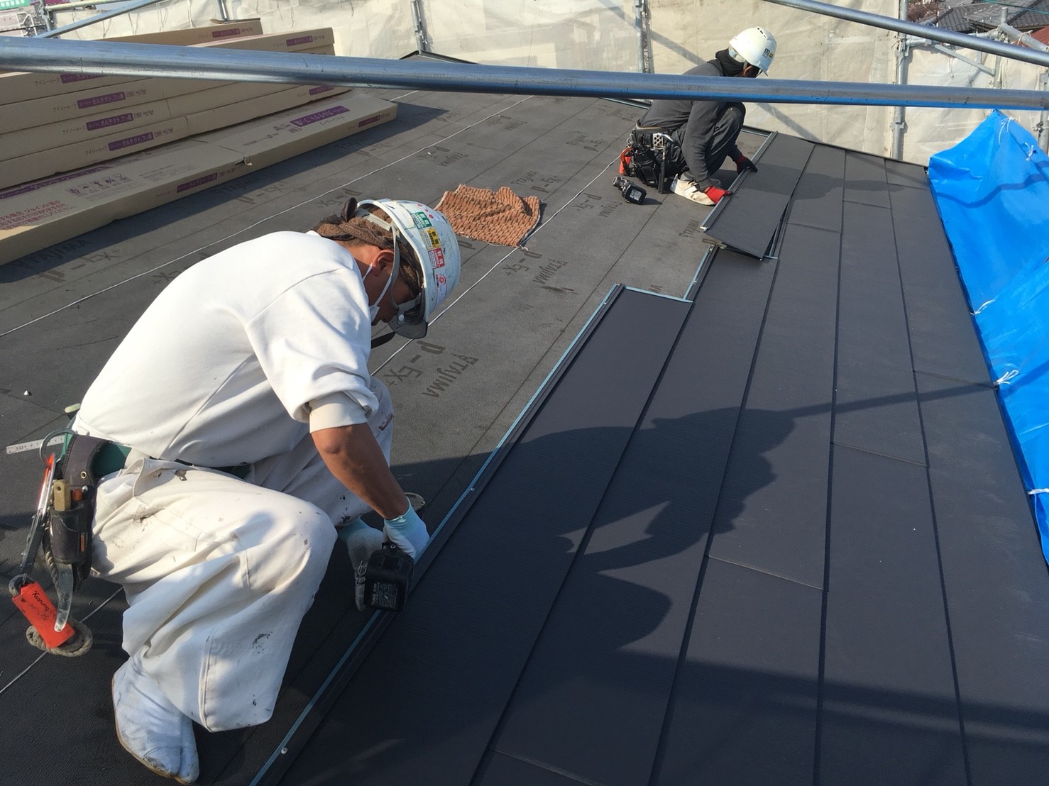 新しい屋根材の取り付け作業（職人による固定）
