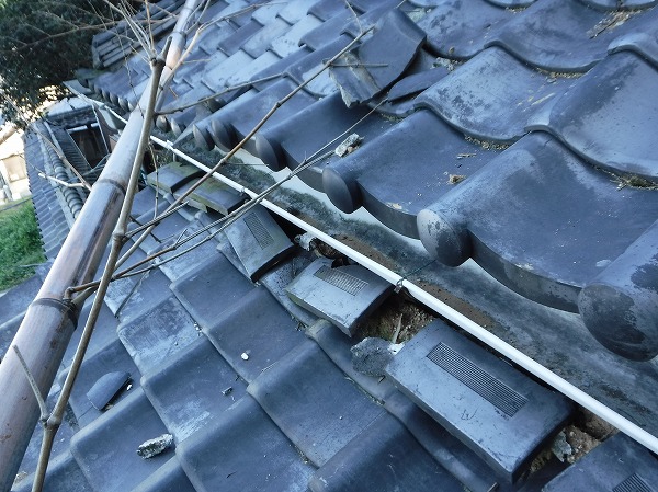 瓦屋根に竹が倒れる