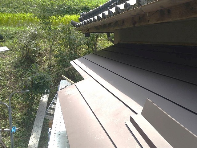 玄関屋根のカバー工事でSGL鋼板屋根本体を葺き上げている施工状況