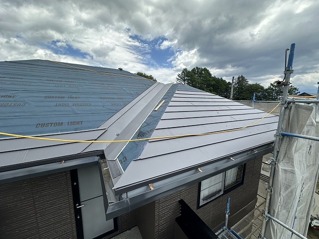 屋根カバー工事で谷板金の設置後にガルバリウム鋼板施工