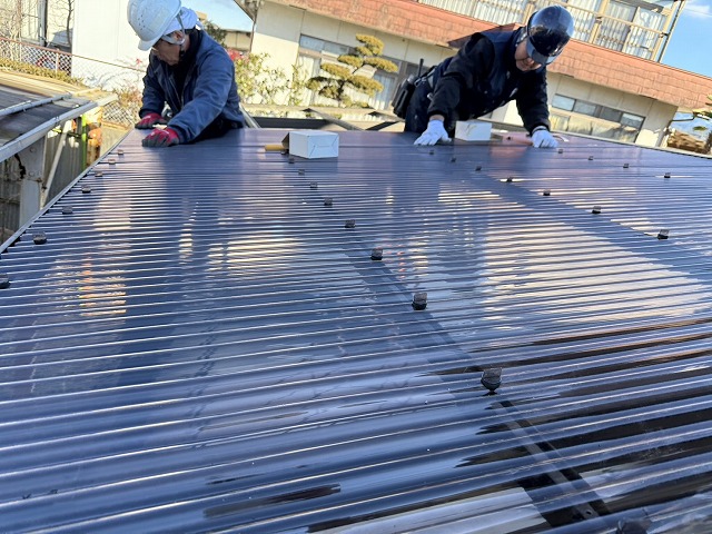 ポリカ屋根張り替え工事で既存カーポート屋根の留め具を取り外している様子