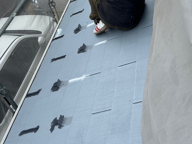 スレート屋根に生じていたひび割れにコーキング材を充填して補修している状況