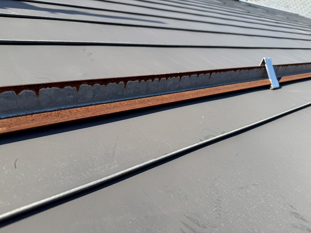 住宅の金属屋根に設置されている雪止め金具にサビが生じている状況