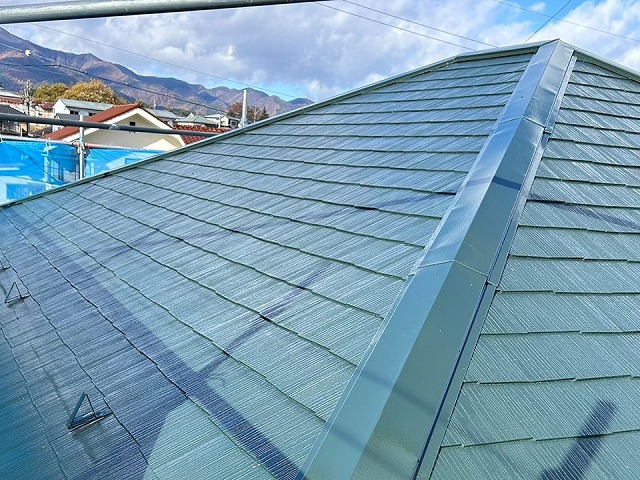 スレート屋根や棟板金への3回塗りによる塗装工程が完了した状況