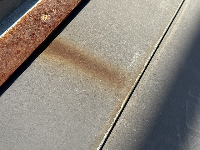 住宅の金属屋根に設置されている雪止め金具のサビが流れている様子