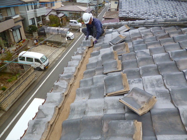 瓦積みなおし作業中のヘルメット姿の職人