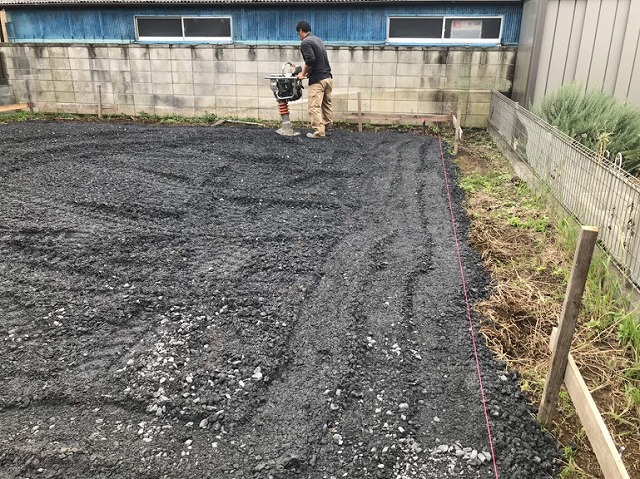 土間コンクリート用の砕石に転圧機をかけているところ