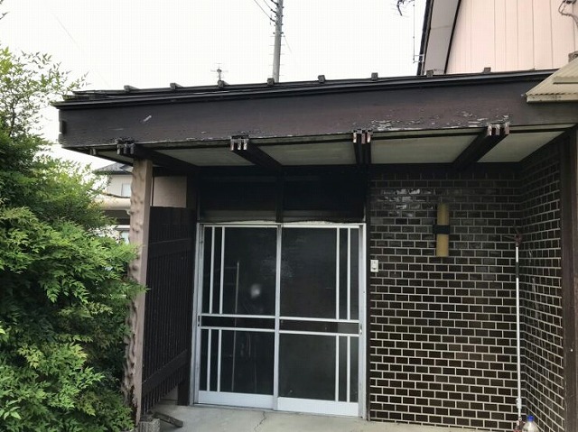 柱の根本が傷んで屋根が傾いた玄関の全景