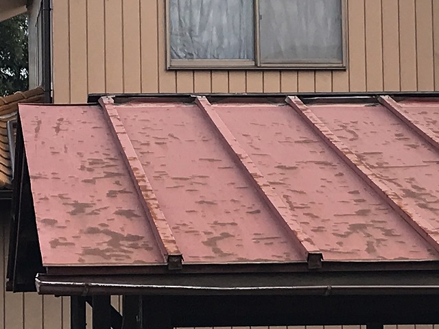 車庫の板金屋根の塗装の剝がれと変形した雨どい