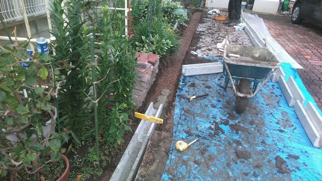 勾配や水平器を使って側溝敷設しているところ